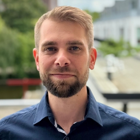 Mann mit Bart und zur&uuml;ckgek&auml;mmten Haaren.