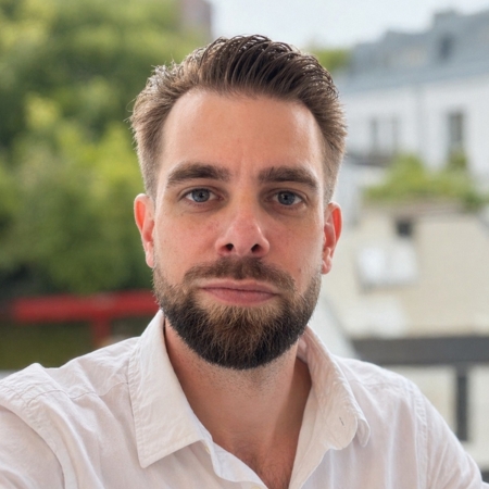 Mann mit Bart und zurückgekämmten Haaren.